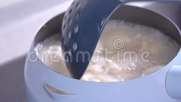 在煤气炉上煮和煮美味的饺子放在淡蓝色的锅里厨房里有水很近生活方式视频的预览图