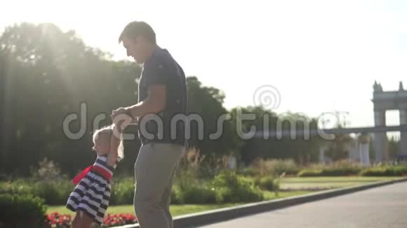 爸爸把他的小女儿缠在他身边公园日落视频的预览图