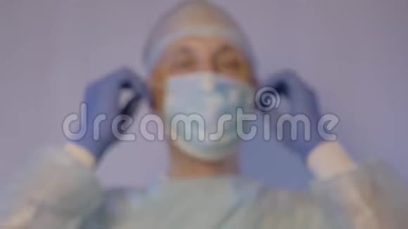 一位白人外科医生在手术后摘下一张医用口罩他很积极向病人示意视频的预览图