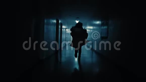 一个年轻的女人沿着黑暗的走廊从追求她的人身边逃跑视频的预览图
