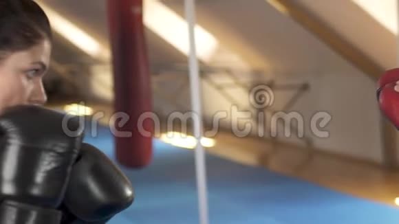 美丽的黑发女子拳击与她的教练在健身健身房慢动作坚强华丽的女人努力锻炼视频的预览图