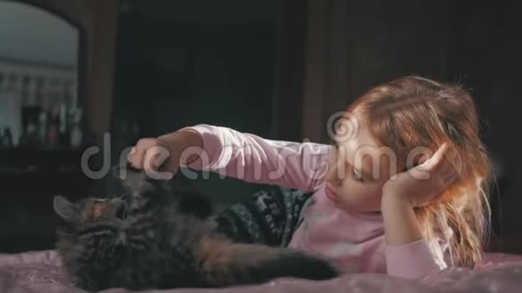 小可爱的女孩在家里和小猫在床上玩视频的预览图