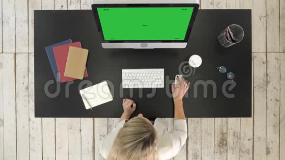 有魅力的年轻商务女士在办公室工作时使用电脑绿色屏幕模拟显示视频的预览图