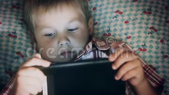 小孩的脸看着平板电脑视频的预览图