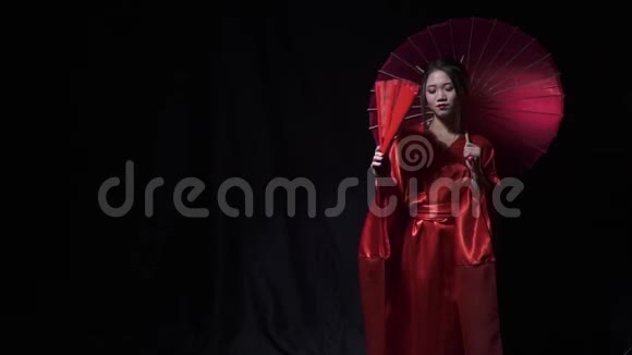 穿着国服的日本妇女在撑伞时缓慢地展开扇子视频的预览图