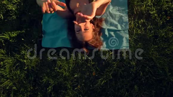 女人躺在草地上一边欣赏舞蹈一边看镜头视频的预览图