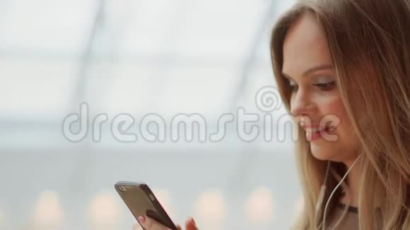 女生特写用手机写短信看智能手机的屏幕通过移动提供视频会议视频的预览图