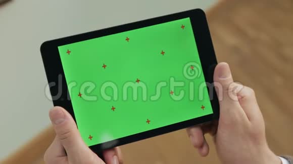男性手拿着绿色屏幕的平板电脑在平板电脑屏幕上做手势的人视频的预览图