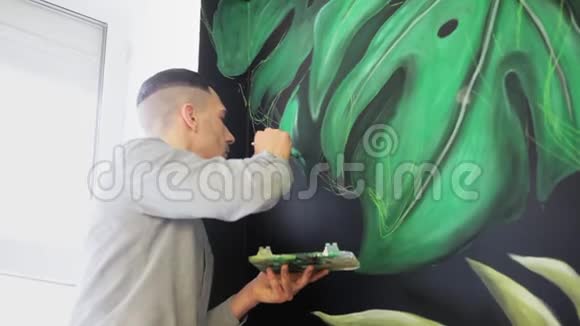 涂鸦艺术家在墙上画油漆用刷子的男性手艺术观念视频的预览图