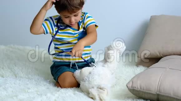 慢动作小男孩扮演医生孩子对待他的玩具兔子医生和病人医药和保健视频的预览图
