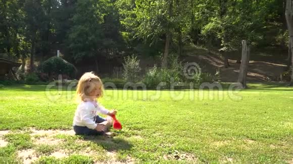 坐在草地上玩玩具的女孩视频的预览图