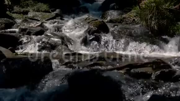 斯洛莫的喀尔巴阡山脉的巨石间流淌着闪闪发光的瀑布飞沫视频的预览图