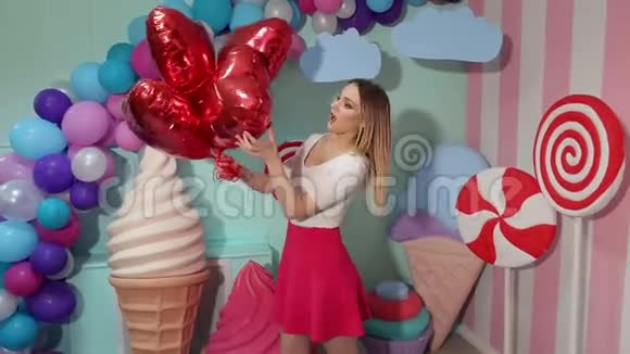 可爱有趣的女孩在糖果派对上带着红色的凝胶气球芭比风格视频的预览图