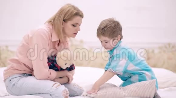 妈妈和小男孩在床上的卧室里说话家庭沟通的概念一个幸福的家庭视频的预览图