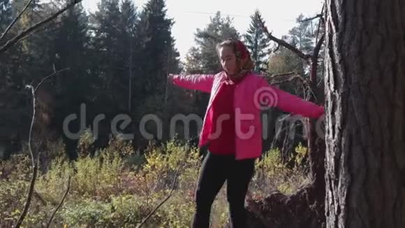 年轻的农村女孩走在原木上与秋天的森林对抗视频的预览图