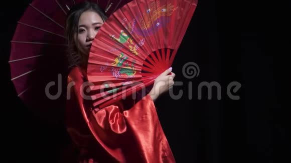 日本女孩拿着扇子和雨伞微微一笑动作缓慢视频的预览图
