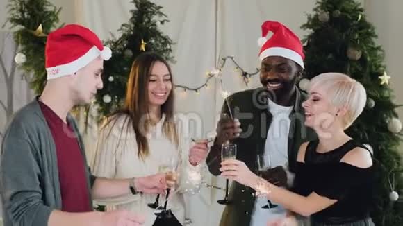 朋友们在一个白色的房间里庆祝新年在一棵美丽的圣诞树旁边有圣诞装饰品吸引力视频的预览图