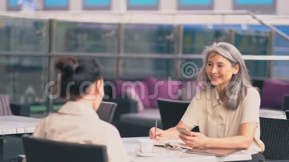 两个女人在办公室坐着说话视频的预览图