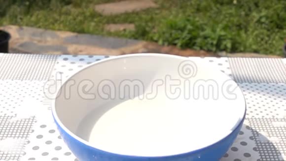 草莓倒在桌上的鲜牛奶碗里视频的预览图