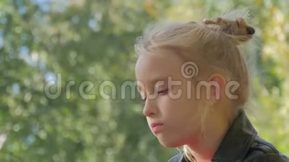 坐在公园长椅上吃三明治的小女孩视频的预览图