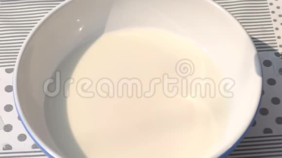 草莓掉进装满新鲜牛奶的白色碗里视频的预览图