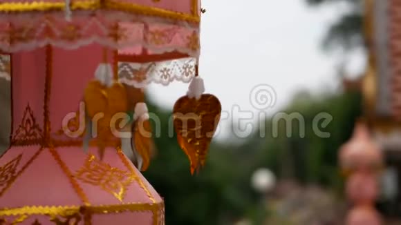 金纸菩提叶贴在寺庙里的佛教吊灯上在微风中移动视频的预览图