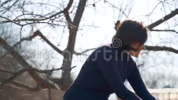 一个女人用耙子耙树的落叶园林地块春季大扫除视频的预览图