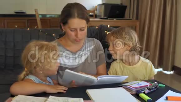 一名教师一名家庭教师一位老师或妈妈和小女孩和男孩在桌子上家庭教育概念视频的预览图