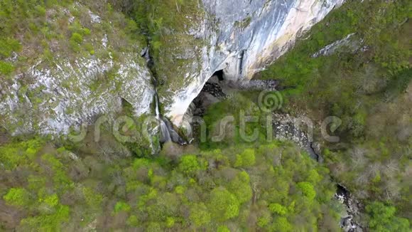 无人驾驶飞机俯瞰瀑布和大洞穴入口视频的预览图