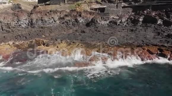 空中射击一波又一波的绿松石还有火山海岸景观是黄色和黄色的大石头视频的预览图