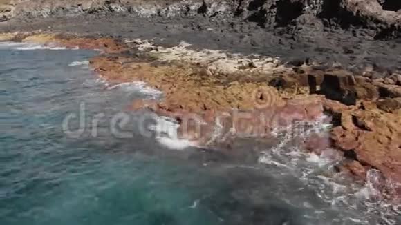 空中射击沿着火山海岸飞行景观是黄色和棕色的大石头到处跳动视频的预览图