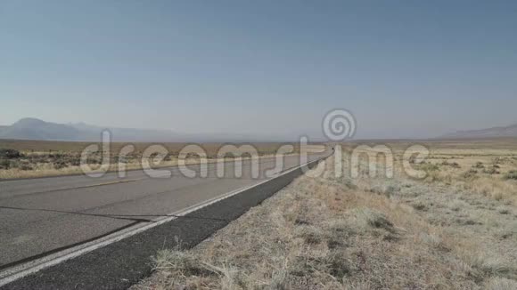 沿着沙漠中的一条路行驶的卡车视频的预览图