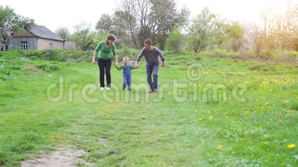 快乐的年轻家庭一起在外面度过绿色的时光视频的预览图