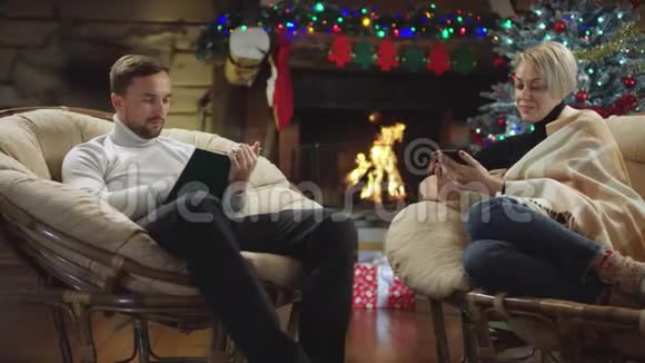 丈夫在智能手机上发短信妻子在圣诞夜看书视频的预览图