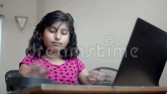 快乐的印度亚裔高加索女孩戴着耳机在笔记本电脑上欣赏音乐点头跳舞和唱歌肖像视频的预览图