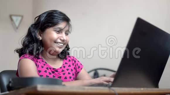 快乐的印度亚裔白种人女孩短毛视频打电话在笔记本电脑上微笑着笑着玩关闭侧视视频的预览图