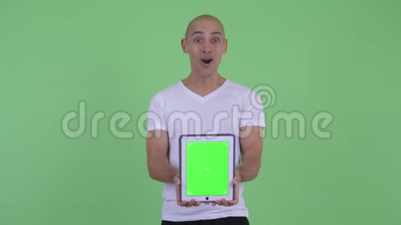快乐帅哥光头男子展示数码平板电脑表情惊喜视频的预览图