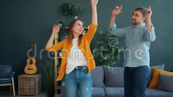 快乐的一对夫妻在家跳舞一起享受休闲时光视频的预览图
