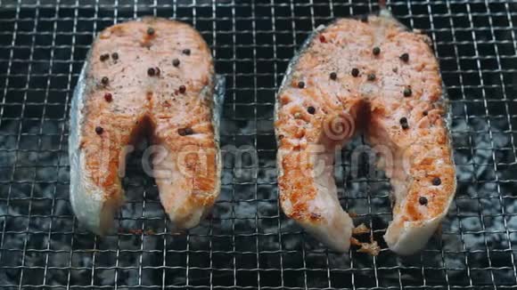 烤三文鱼牛排烧烤把烤三文鱼片放在木炭上视频的预览图