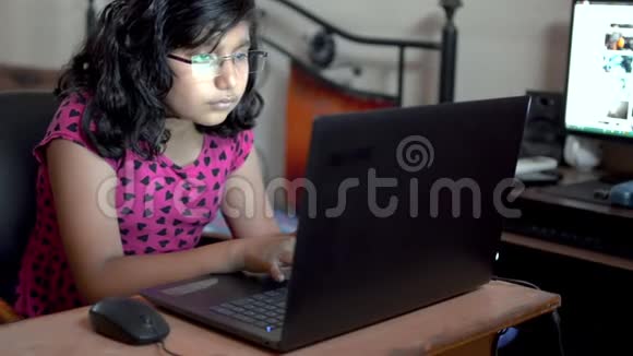 印度白人女孩晚上在室内办公室戴眼镜在笔记本电脑上打字关门视频的预览图