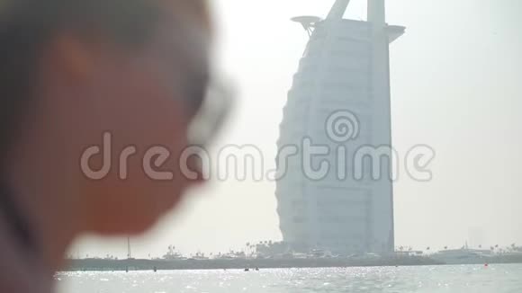 戴着太阳镜的漂亮女孩在迪拜的城市公共海滩上休息特写视频的预览图