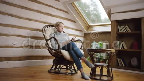 坐在椅子上用智能手机的美女视频的预览图