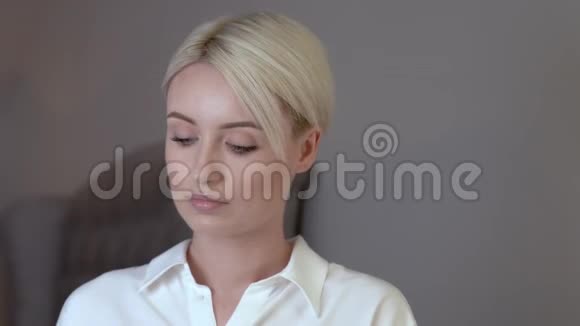 一个可爱的短发金发女人用刷子在他眼皮上画了个阴影视频的预览图