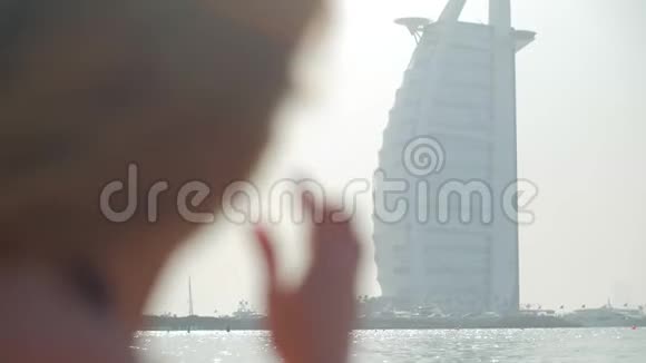 在迪拜的一个城市公共海滩上戴着太阳镜微笑的年轻女孩特写镜头视频的预览图