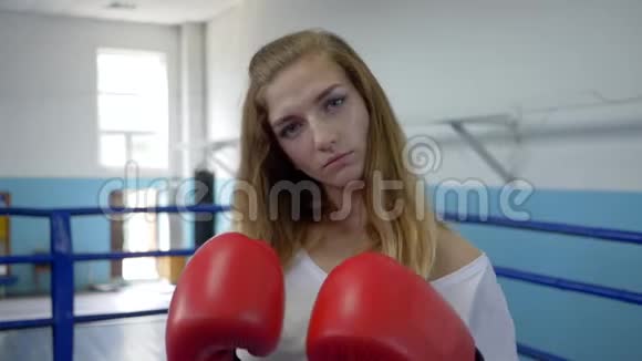 女运动员在拳击场打拳击前先把拳击手套预热视频的预览图