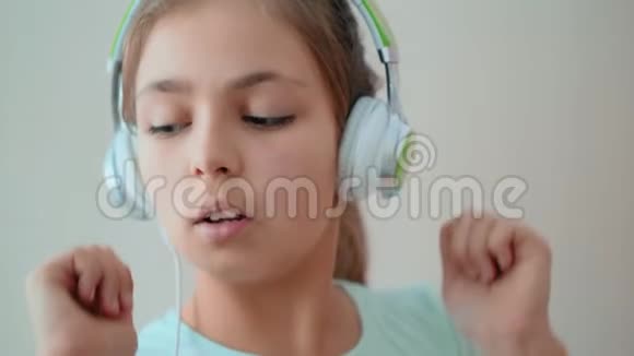 可爱的少女通过耳机听音乐视频的预览图