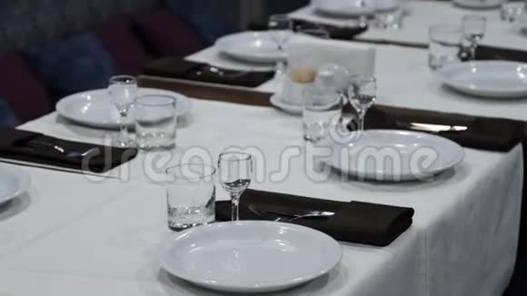 餐厅的桌子设置盘子眼镜和其他厨具站在一张长桌子上视频的预览图