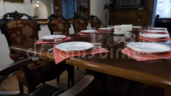 一家著名餐厅的餐桌设置深盘和玻璃杯叉在一张别致的抛光木桌上视频的预览图