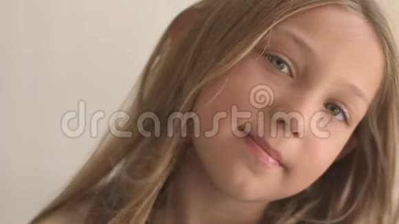 蓝色眼睛和金色头发的快乐少女的特写肖像站在风上微风在玩弄女孩的头发暴风雨视频的预览图