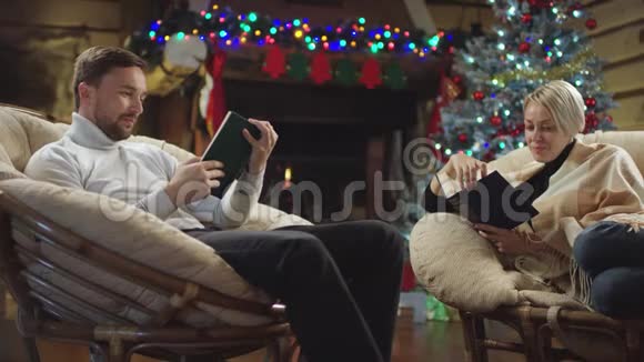 一对情侣在壁炉旁看新年的书视频的预览图
